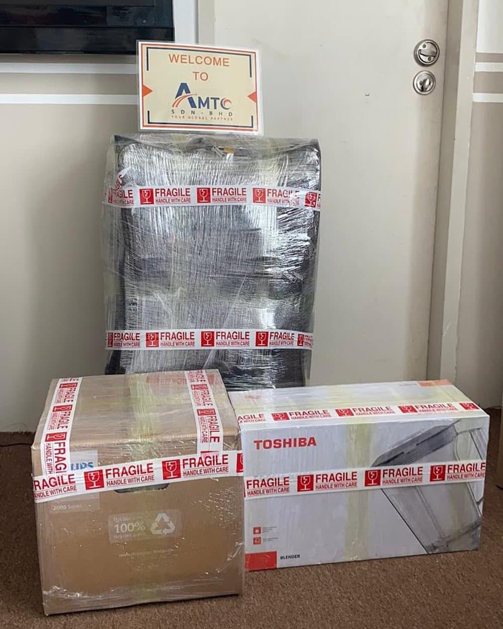 A suitcase and household appliances, wrapped and ready to ship