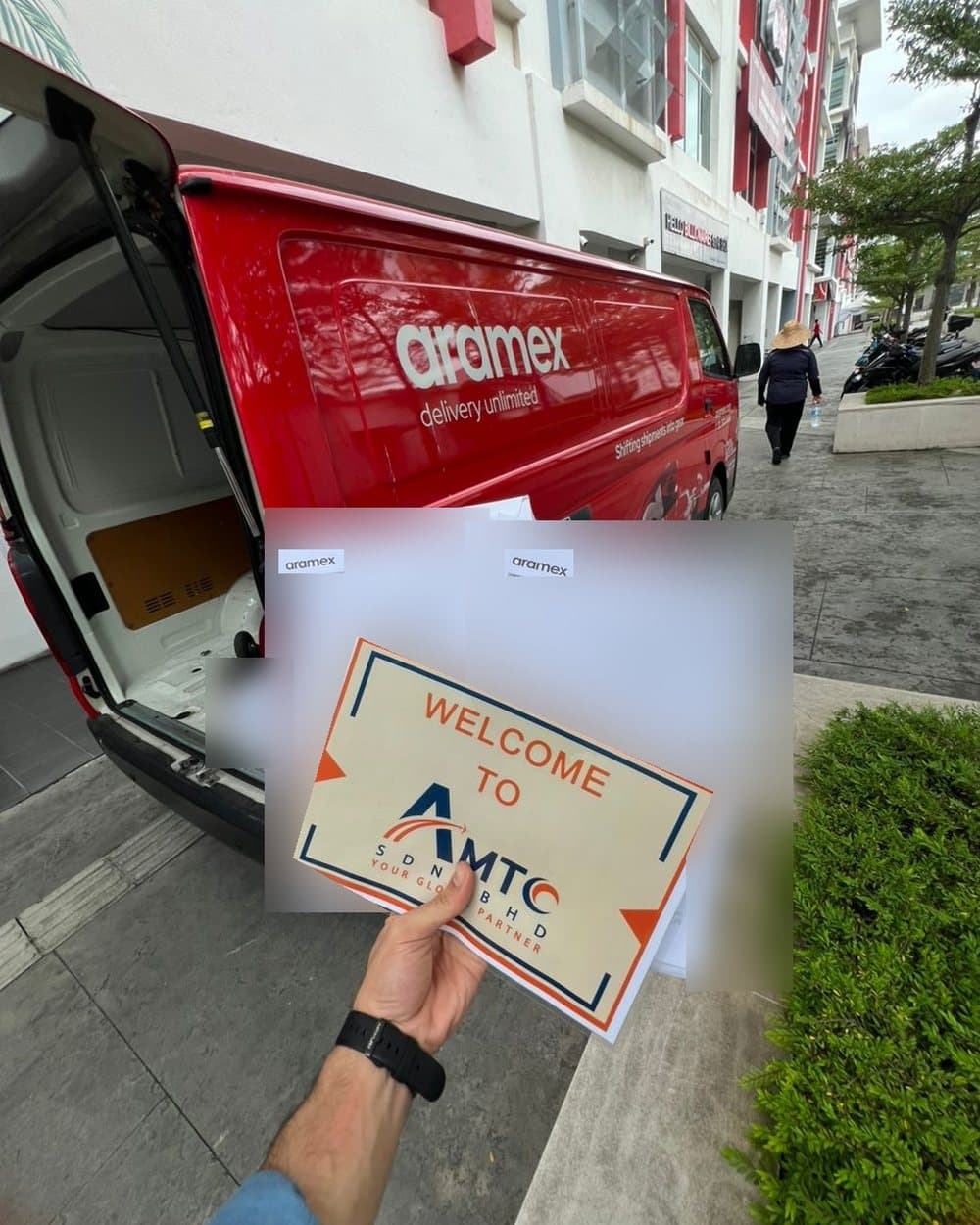 Two waybills and an AMTC welcome sign by an Aramex van