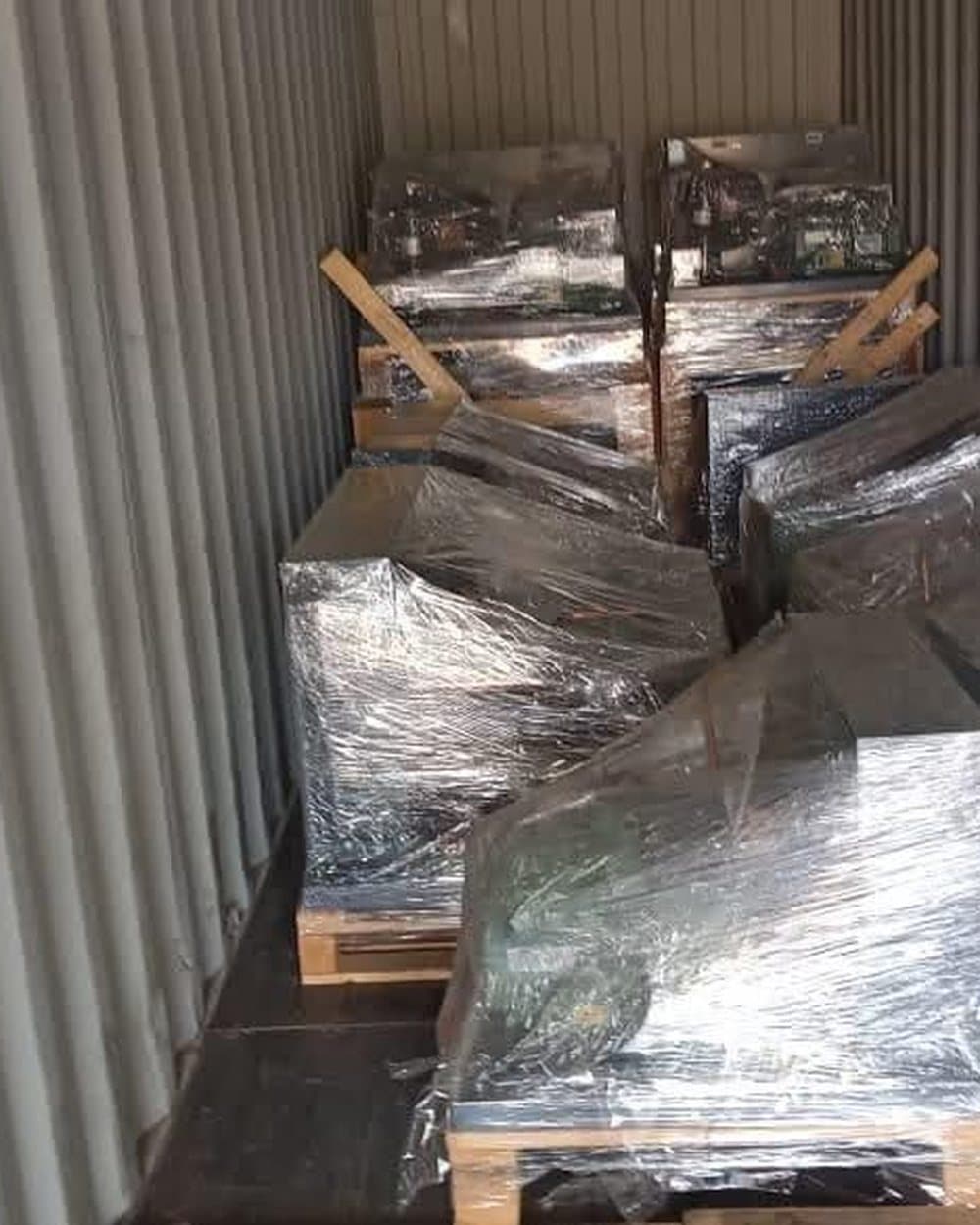 Wrapped machines on pallets inside a shipping container