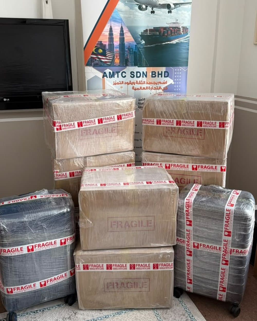 Wrapped boxes and suitcases in front of the AMTC banner