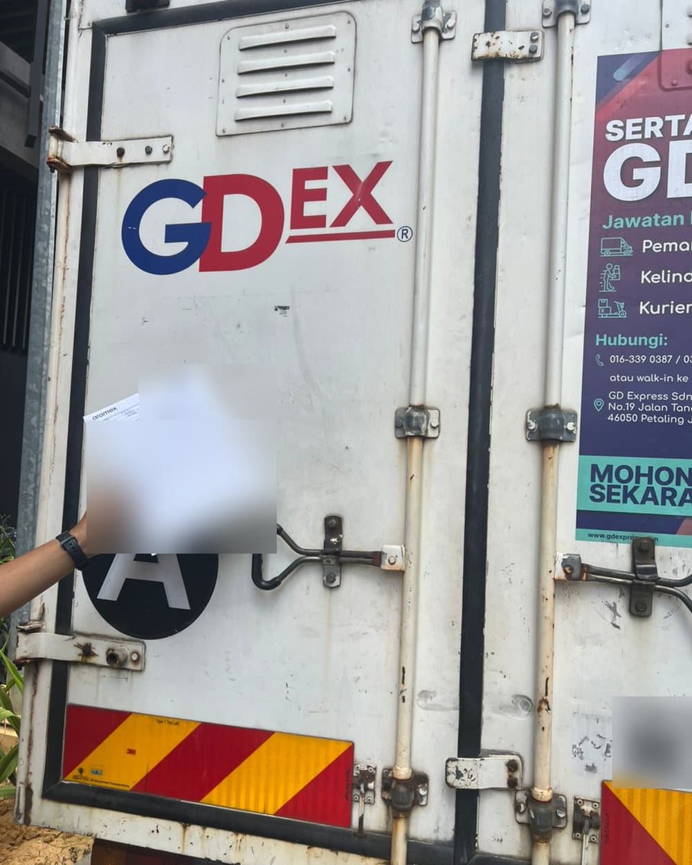 A waybill held up at a delivery truck
