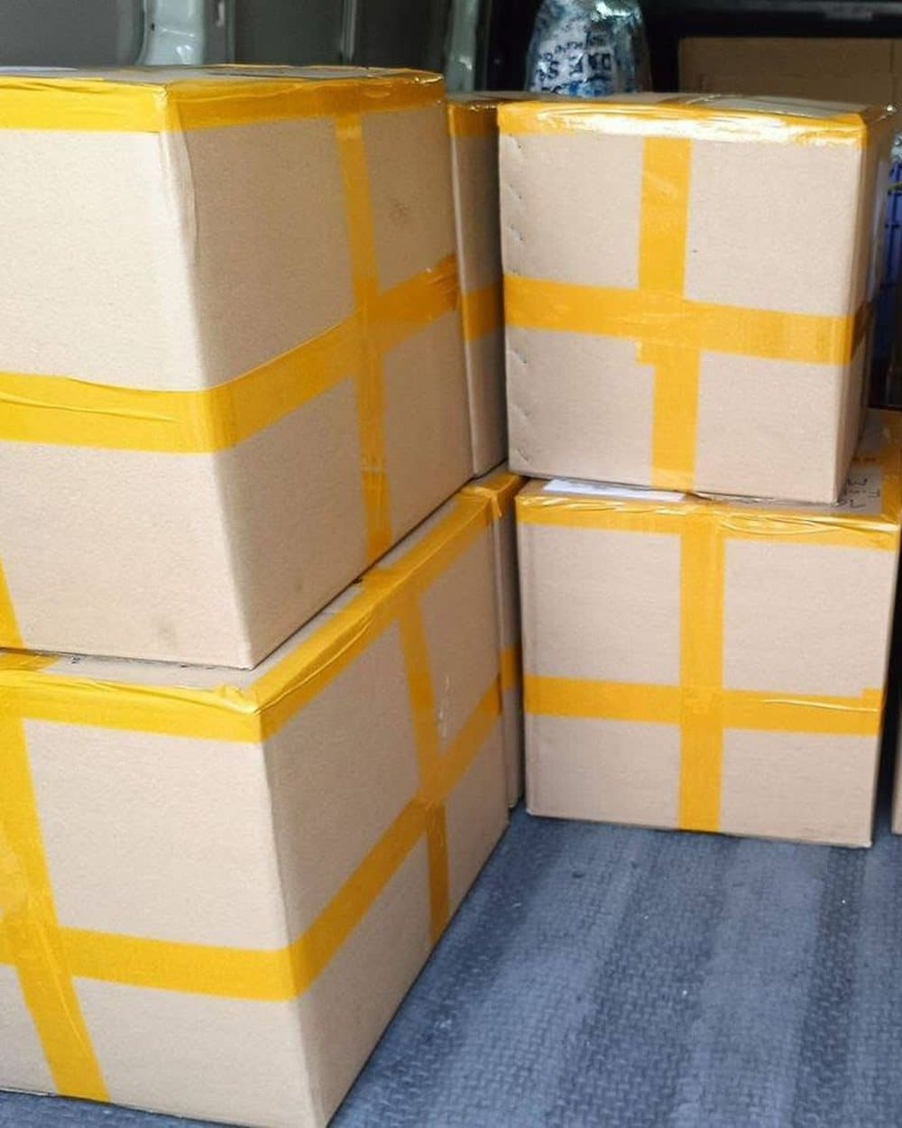 Boxes sealed with yellow tape in a van